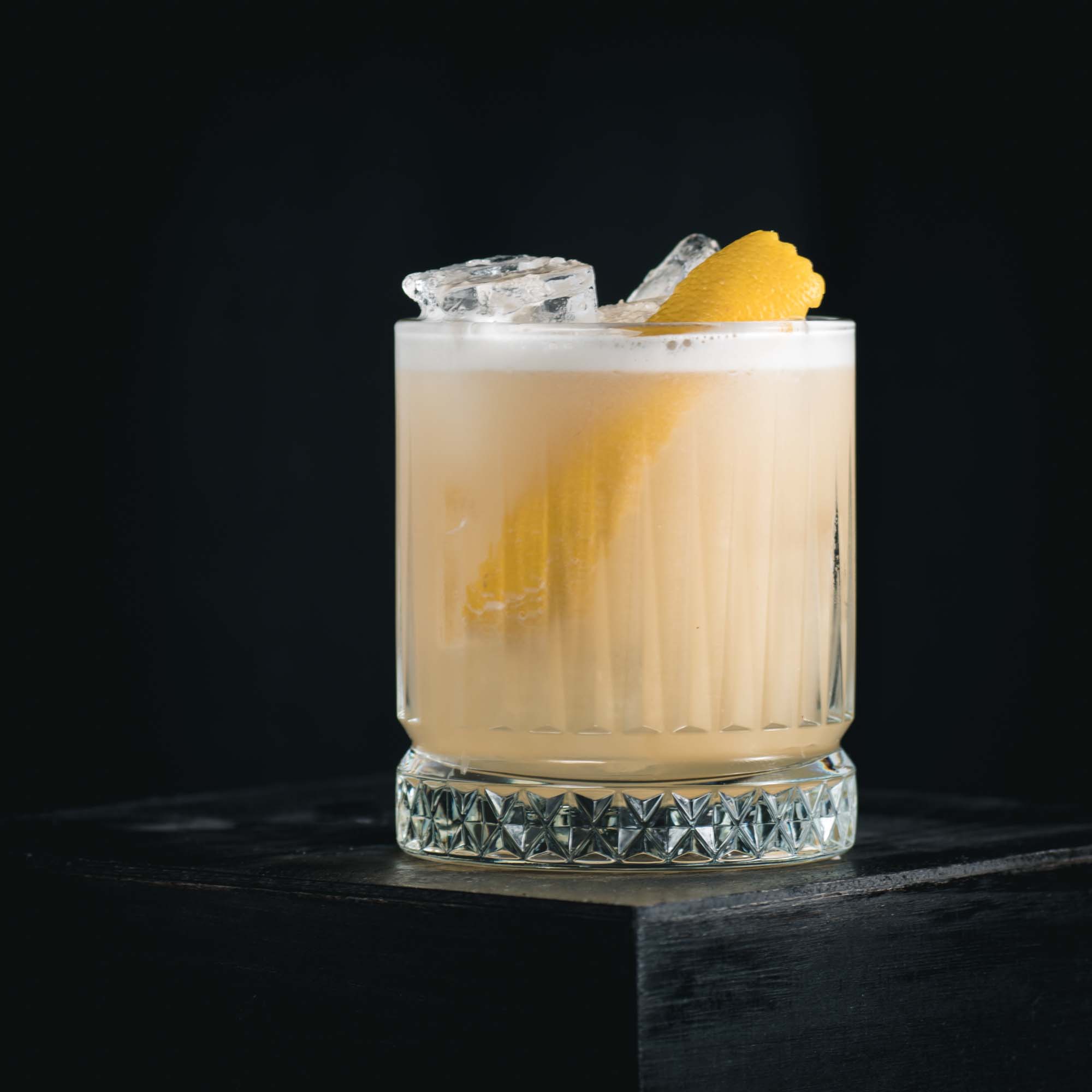 Ein Whiskey Sour mit Bourbon Whiskey, Zitronensaft, Zuckersirup und Eiweiß.