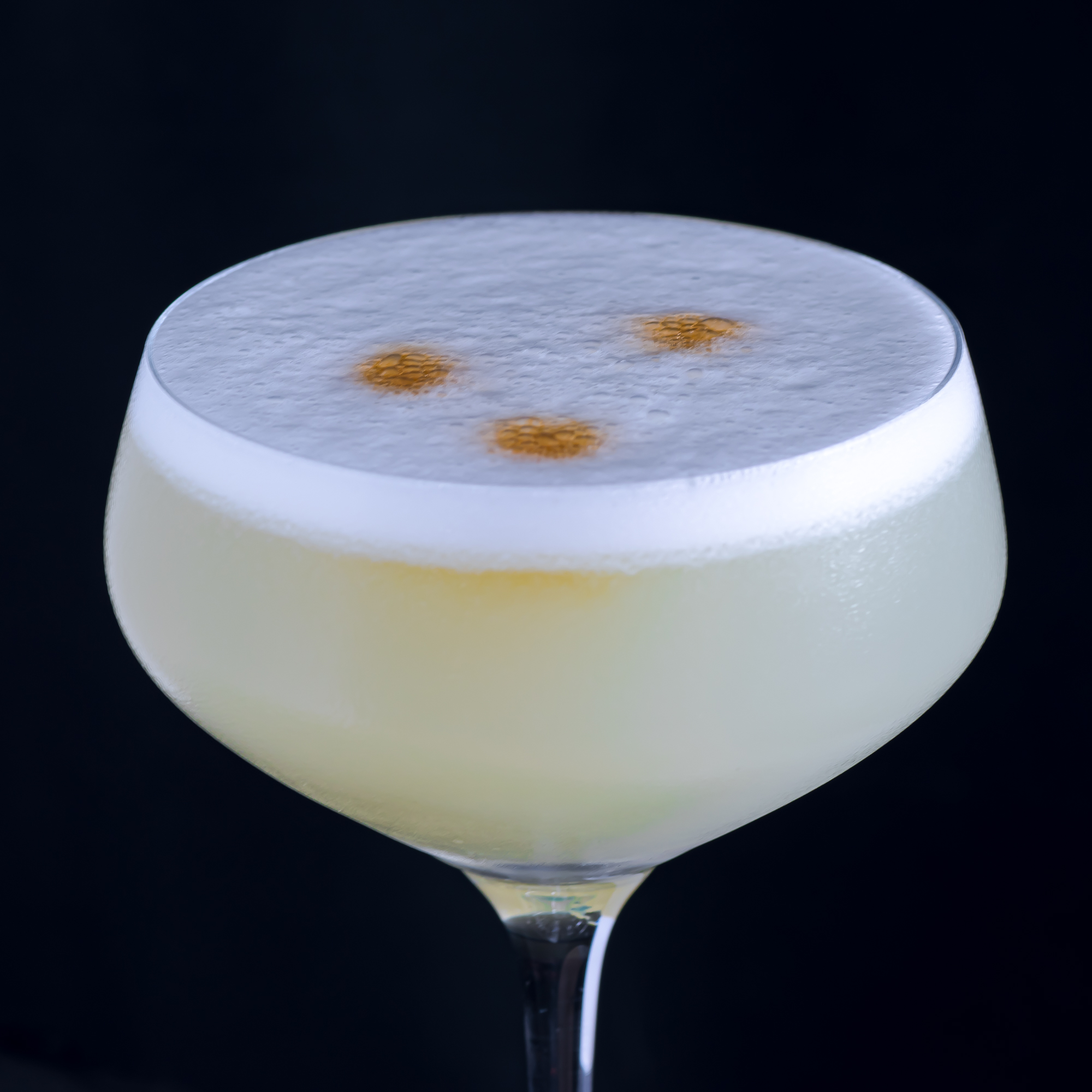 Die Garnitur für einen peruanischen Pisco Sour sind drei Spritzer Cocktail Bitters.